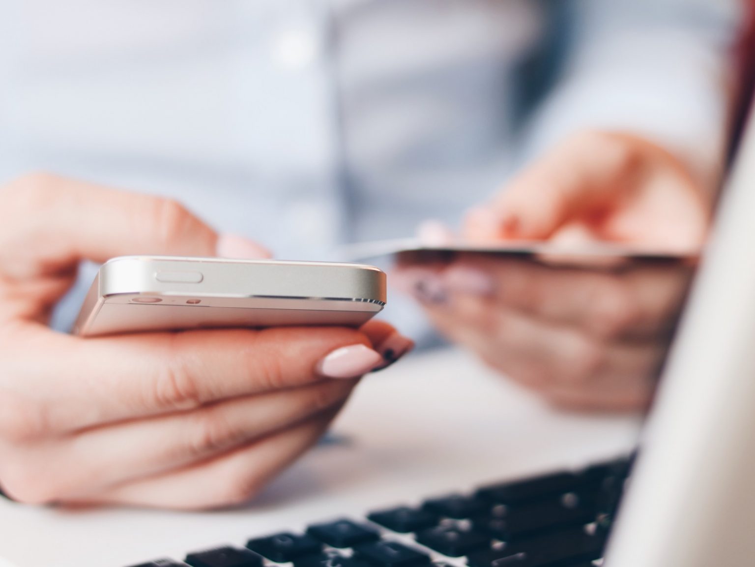 Photo d'une femme utilisant son portable et sa carte bancaire